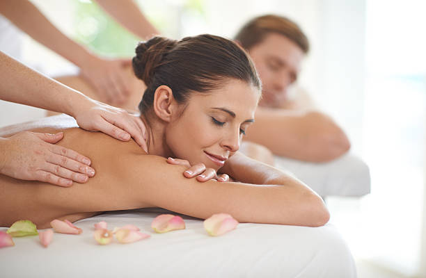 A husband and wife lying receiving massages at a spa