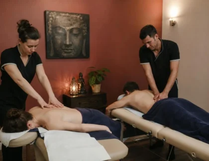 Massage duo Toulouse : deux thérapeutes travaillent en simultané sur des clients allongés, premier plan et lumière douce.